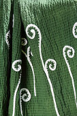 Green blanket hand-decorated with sequinned fern motifs