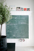 Chalkboard and children's pictures on wood-clad wall