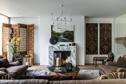 Exotic, eclectic mixture of styles in living room with marble fire surround