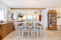 Festively set dining table in open-plan, country-house-style interior