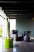 Kaktus und Designersessel im Wohnzimmer mit Balkendecke