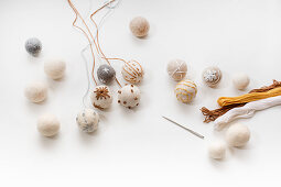 Embroidering felt balls with wintry motifs