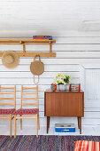 Chairs and cabinet against board wall in rustic wooden house