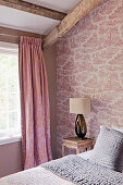 Patterned curtains in bedroom with toile de jouy wallpaper
