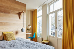 Doppelbett an Raumteiler aus Holz in hellem Schlafzimmer