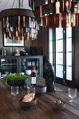 Leather-fringed lampshades above raven figurine on dining table