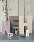 Pastel decorative letters made from old books in front of wooden wall