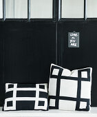 Black-and-white cushions in front of black metal door