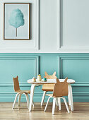 Children's chairs with ears at the table in front of a two-coloured coffered wall