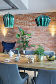 Grey upholstered chairs at dining table in front of brick wall