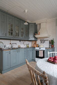 Grey cupboards in rustic kitchen-dining room in country-house style