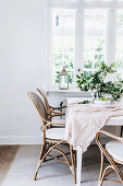 White table with rattan chairs by the window