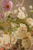 Biscuits iced to look like quails' eggs hanging from branch