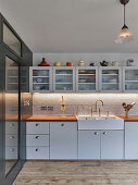 Classic kitchen in white with glass-fronted wall units and stoneware sink