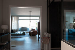 Blick von der Diele mit schwarzer Metallkonsole ins Wohnzimmer