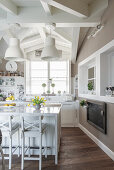 Pendant lamps above island counter with bar stools in country-house kitchen