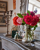 Cut roses in glass vase on mantelpiece