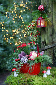 Festive arrangement in red and green with roses and fly agaric mushroom ornaments