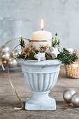 Wintry arrangement of candle and dried flowers in flower pot
