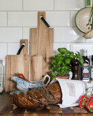 Brot, Holzbretter und Basilikum auf Küchenarbeitsplatte
