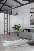 Grey sofa and child's swing in loft apartment