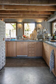 Moderne Landhausküche mit Holzfronten und Balkendecke