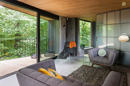 Grey sofa set in front of glass sliding door in open-plan interior