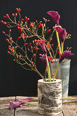 Rosehips and Calla lilies in birch trunk and zinc cups