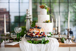 Two celebration cakes, candlesticks and wine glasses on festively set table