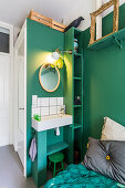 Waschbecken und Spiegel an grüner Wand