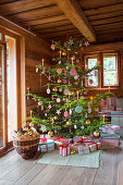 Christmas tree decorated with small embroidery frames and wrapped gifts in pastel shades