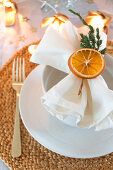 Napkin decorated with dried orange slice and juniper twig