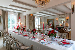 Table festively set in red and white in elegant interior