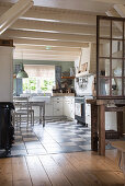 A view into a kitchen with a chequerboard floor and a wooden ceiling