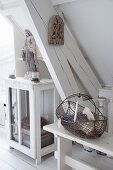 A wire basket on a bench in front of wooden beams next to a cupboard with religious statue in a shabby-chic style room