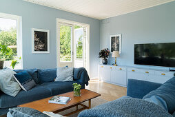 A blue sofa suite and a television on a lowboard in a living room