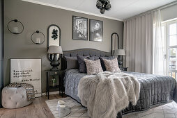 A double bed in a bedroom with a taupe wall