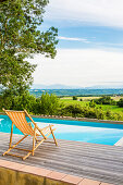 Deck chair by the pool with landscape view