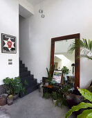 Bodenspiegel und viele Zimmerpflanzen vor der grauen Treppe