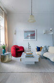 Red armchair, golden side table and beige sofa in living room