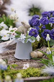 Small Easter decoration with flowers of filled primrose, pushkinia, Cherry plum blossoms, and grape hyacinth, Easter bunny, and Easter eggs