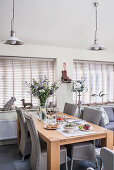 Pendant lights and closed Venetian blinds with wooden table