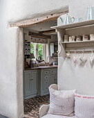Hearts hang on wall mounted shelf with view to kitchen