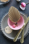 Paper fan in dish decorating place setting on table