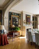 Paintings on walls with stucco details in classic dining room