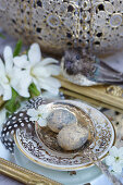 Easter eggs with a cherry blossom on a silver spoon