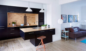 Contemporary kitchen with black cupboard fronts and free-standing counter