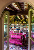 Upholstered bench with pink cover and desk in the library