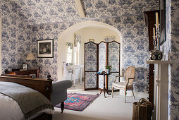 Classic bedroom with blue-and-white wallpaper and ensuite bathroom