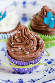 Cupcakes with chocolate frosting and silver dragees love beads in colorful cupcake liners